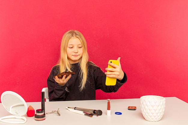 Blogger di bellezza ragazza. Teen bionda in posa sulla fotocamera e fare vlog.