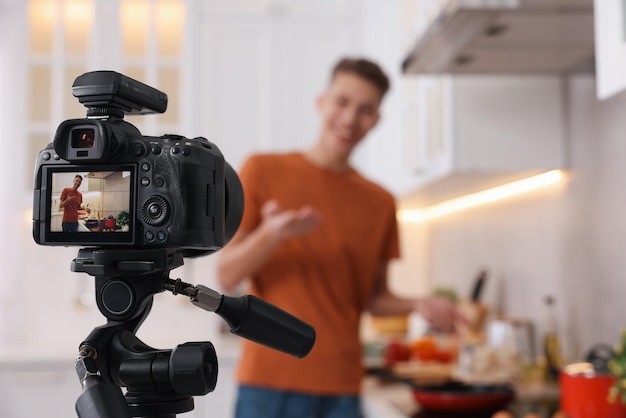Blogger di cibo che registra video in cucina si concentra sulla telecamera