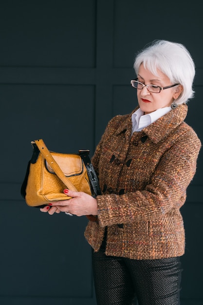 blogger di stilista di moda senior. signora anziana in abito autunnale alla moda ripresa vlog.