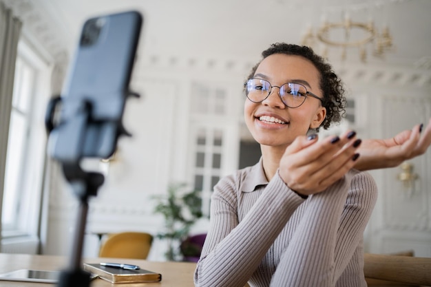 Blogger donna lavoro ufficio moderno utilizza comunicazione telefonica comunicazione video online con i colleghi