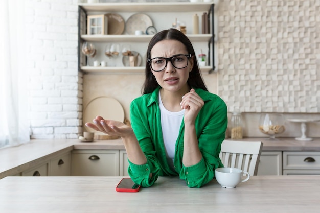 Blogging webinar blogger giovane e bella donna seria che parla alla telecamera di problemi confusi