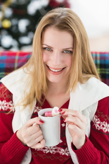 Blonde sorridente in vestiti di inverno che tengono tazza