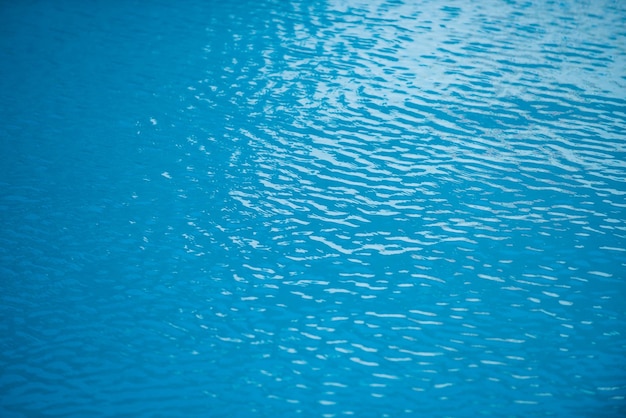 Blu acqua piscina sfondo sfocato trasparente chiaro acqua calma superficie texture onde d'acqua in sunli