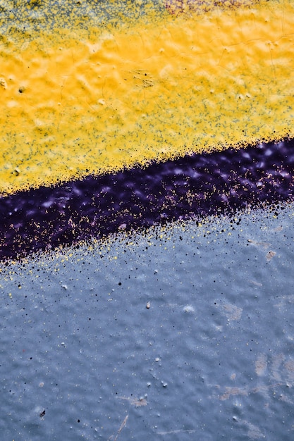 Blu pallido, vernice gialla e linea viola sul muro di gesso.