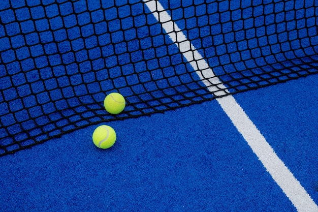 Blue artificial grass paddle tennis court due palle vicino alla rete