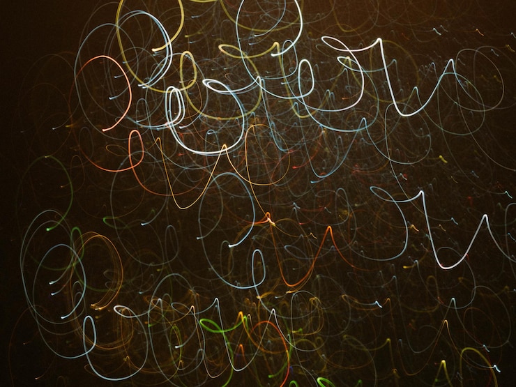 Photo blur multicolor illuminated swirly lines. defocused light and rays. dark abstract art background.