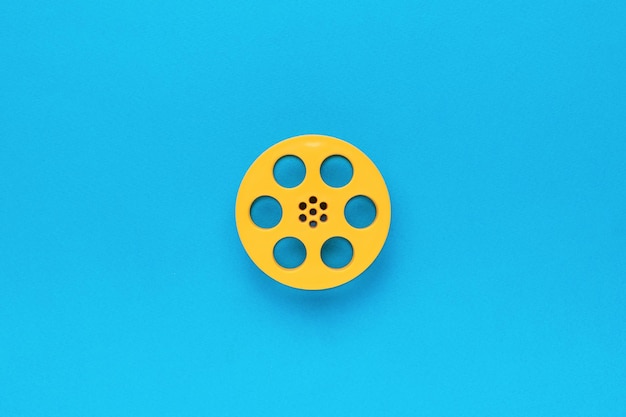 Bobina di film plastico su sfondo blu Il concetto minimo di cinema Piatto lay