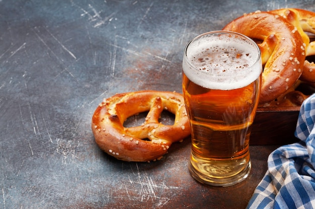 Boccale di birra chiara e pretzel fatti in casa appena sfornati