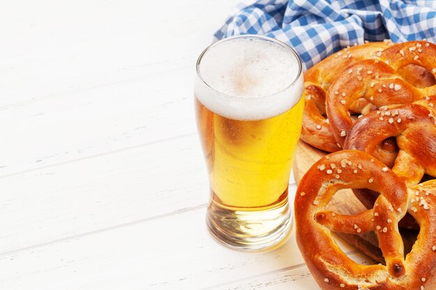 Boccale di birra chiara e pretzel fatti in casa appena sfornati