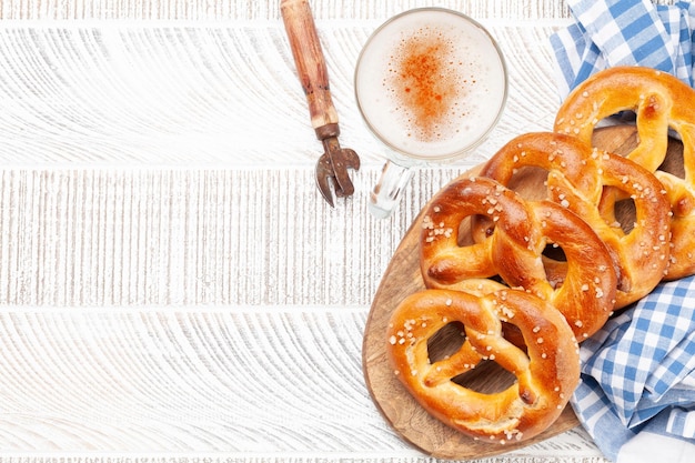 Boccale di birra chiara e pretzel fatti in casa appena sfornati