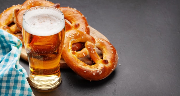 Boccale di birra chiara e pretzel fatti in casa appena sfornati