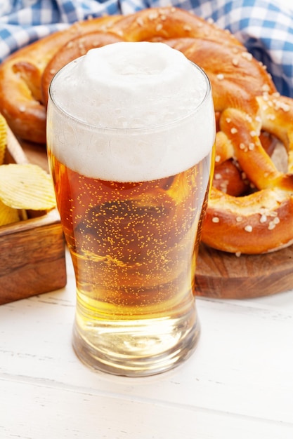 Boccale di birra chiara e pretzel fatti in casa appena sfornati
