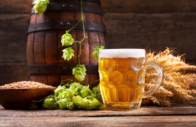 Boccale di birra con luppolo verde e spighe di grano