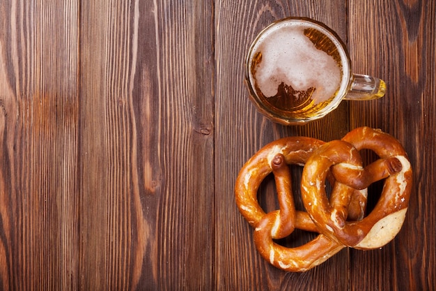 Boccale di birra e pretzel sulla tavola di legno