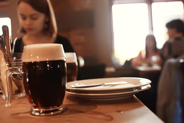 boccale di birra su uno sfondo sfocato / ristorante della birra bella birra scura in una tazza all'interno di un pub