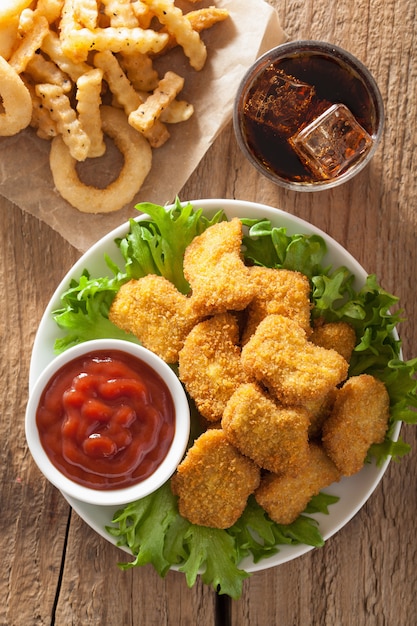 Bocconcini di pollo fast food con ketchup, patatine fritte, cola