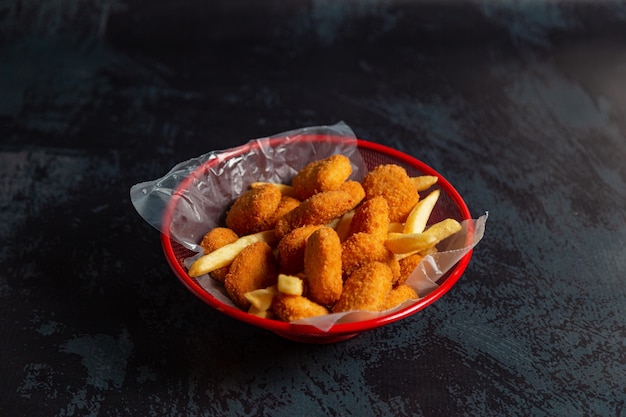 bocconcini di pollo in pentola rossa con patatine fritte