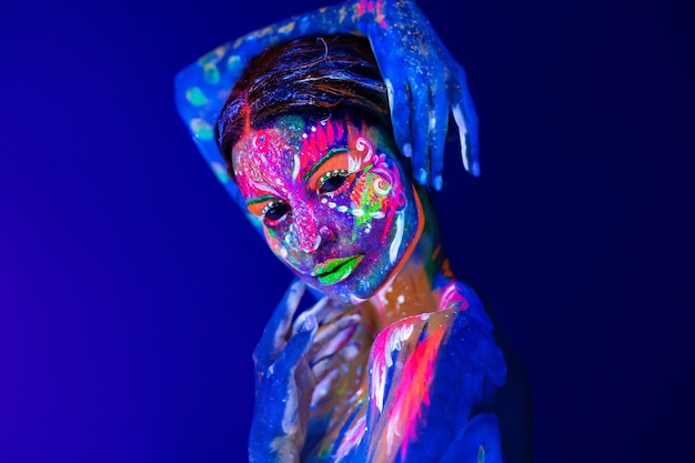 Body art incandescente in luce ultravioletta Body art sul corpo e la mano di una ragazza incandescente