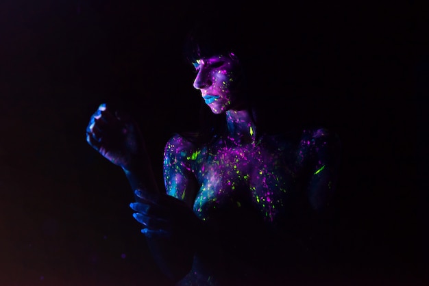 Bodypainting su ragazza nuda dipinta con colori UV