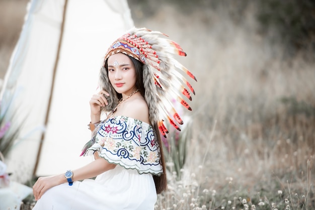 Boho ragazza bohémien in stile indossando un maxi abito indiano e gioielli in campo autunnale