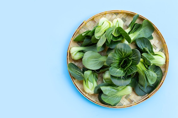 Bok choy nel canestro di bambù sulla superficie blu