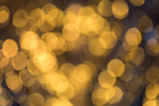 Bokeh di festa di scintillio dell'oro vago estratto luminoso