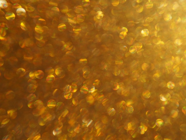Bokeh luce d'oro luccica Sfondo texture glitter dorato Carta da imballaggio glitterata scintillante con paillettes e scintillii Bokeh dorato festivo e glitter Bellissimo sfondo macro