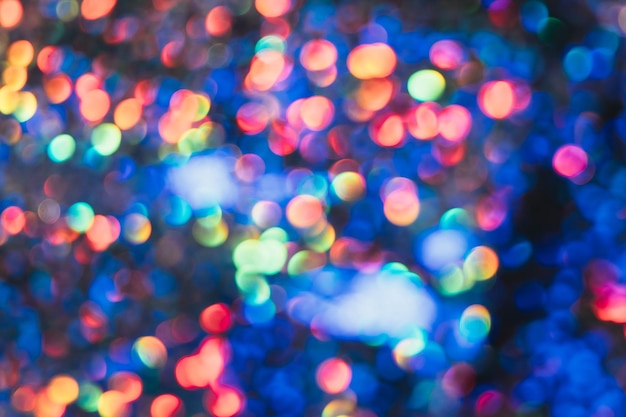 Bokeh sfondo chiaro Scintillii colorati Sfocatura delle luci della città Luce notturna per feste Illuminazione da discoteca Cerchi sfocati blu arancione rosa lucidi su oscurità astratta