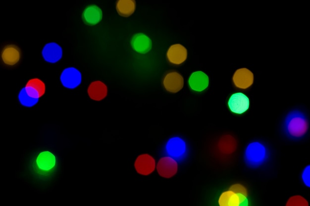 Bokeh variopinto di natale isolato su fondo nero. Sfondo chiaro albero di Natale. Ne