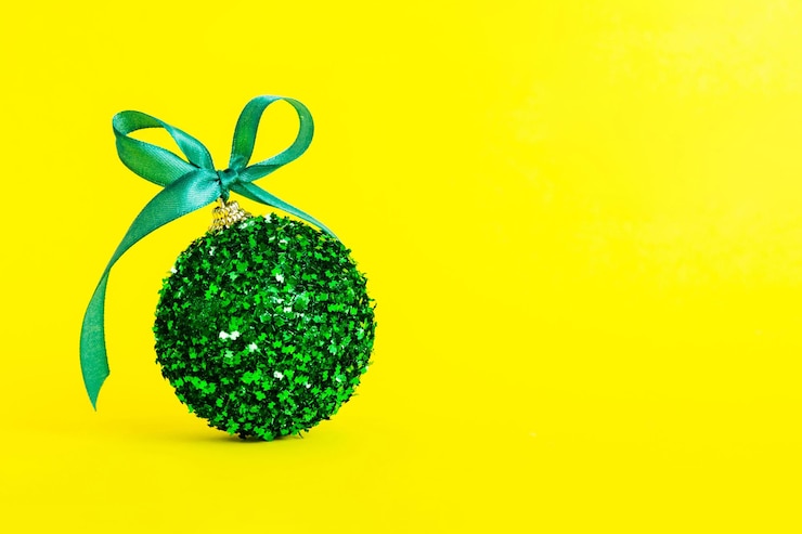 Photo bola natal pada dekorasi latar belakang berwarna, pernak-pernik dengan pita dan ruang kosong
