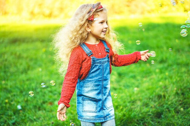 Bolle di salto della bambina graziosa nel parco.