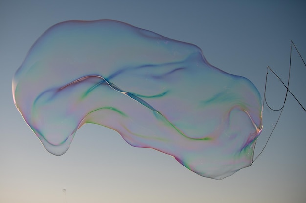 Bolle di sapone con riflessione arcobaleno Buble al cielo blu Bubble party