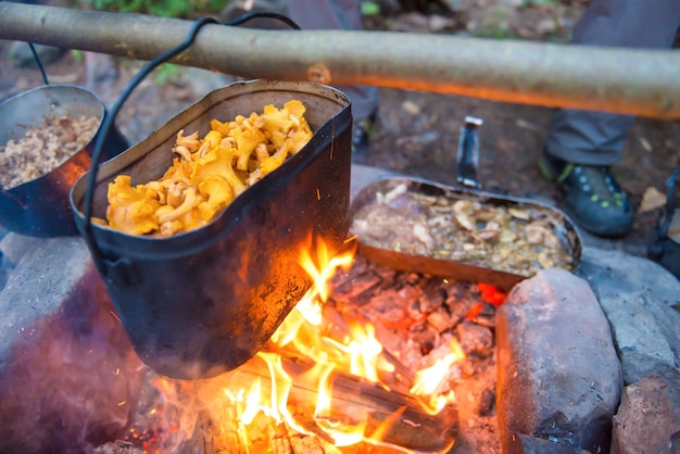 Bollitore pieno di funghi sul fuoco