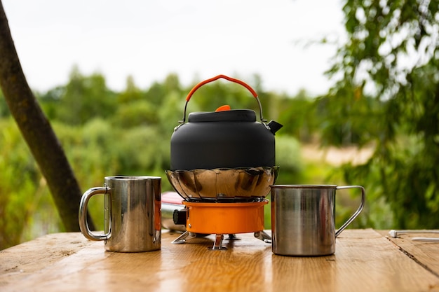 Bollitore turistico su un bruciatore a gas. Cucinare in condizioni di campo. Utilizzando un bruciatore a gas turistico