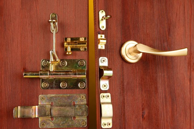 Bolti metallici, serrature e ganci in una porta in legno aperta