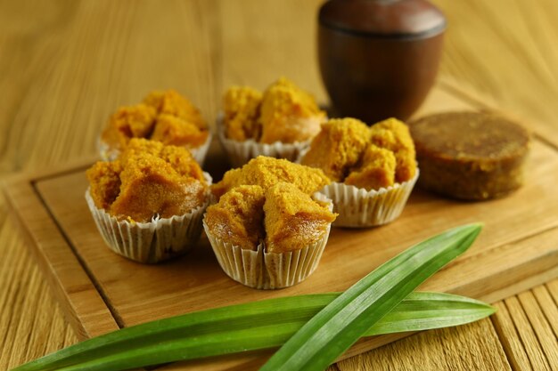 Bolu kukus gula merah o pan di spagna al vapore con zucchero di canna su un piatto di legno con foglia di pandano