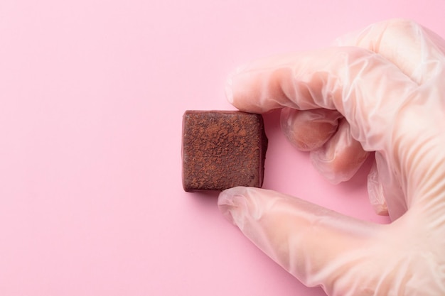 Bonbon di cioccolato artigianale in una mano umana in un guanto