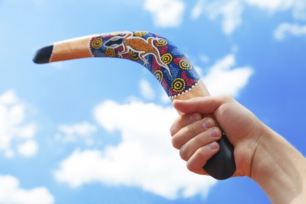 Boomerang in legno con cielo azzurro e sfondo di nuvole