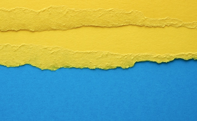 Bordi strappati di carta gialla su sfondo blu