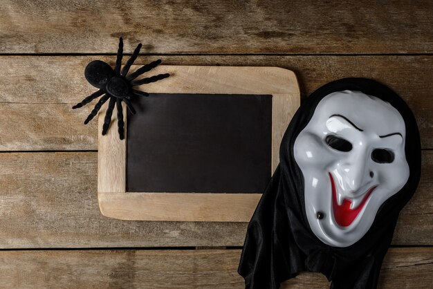 Bordo di gesso di Halloween e ragno giocattolo nero, maschera di strega