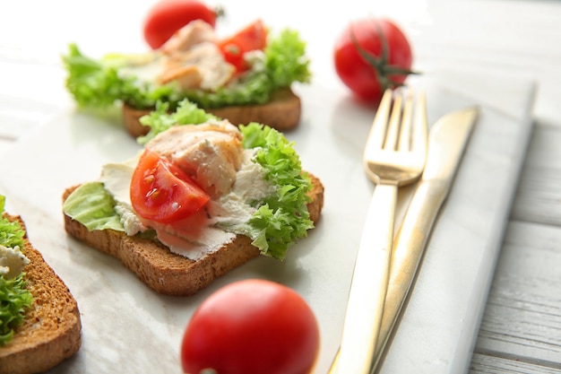 Bordo di marmo con il primo piano gustoso delle bruschette di pollo