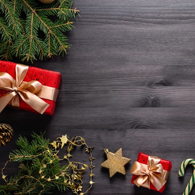 Bordo di Natale con pino, regali, elementi dorati sul nero