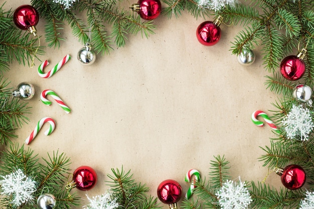 Bordo di Natale festivo con palline rosse e argento su rami di abete e fiocchi di neve su fondo beige rustico