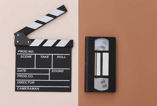 Bordo di valvola di film e videocassetta su fondo marrone beige. Produzione cinematografica, produzione cinematografica, industria dello spettacolo. Vista dall'alto