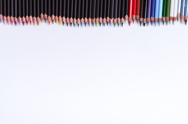 Bordo multicolore di pittura da matite colorate per la creatività artistica su uno sfondo bianco. Disteso
