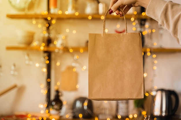 Borsa artigianale per lo shopping a capodanno. Borsa su sfondo di luci di Natale. Saldi di Capodanno