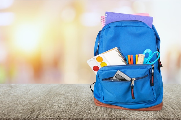 Borsa da scuola su sfondo di legno.