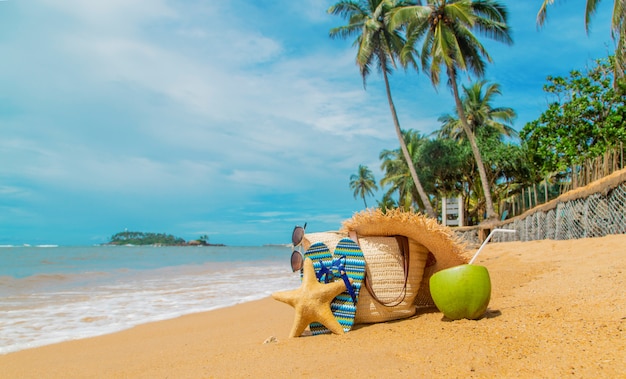 Borsa da spiaggia e cocco in mare.