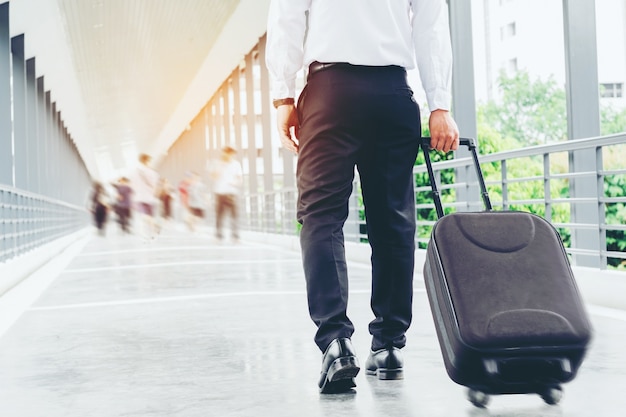 Borsa del carrello della tenuta dell&#39;uomo d&#39;affari che va su sul viaggio