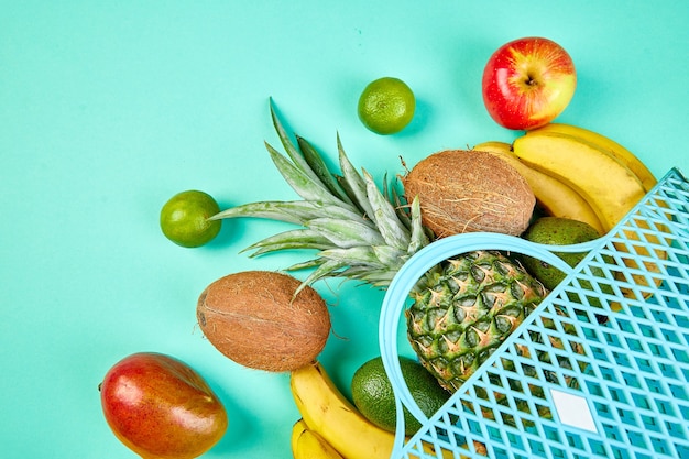 Borsa della spesa con frutta esotica biologica su sfondo blu.